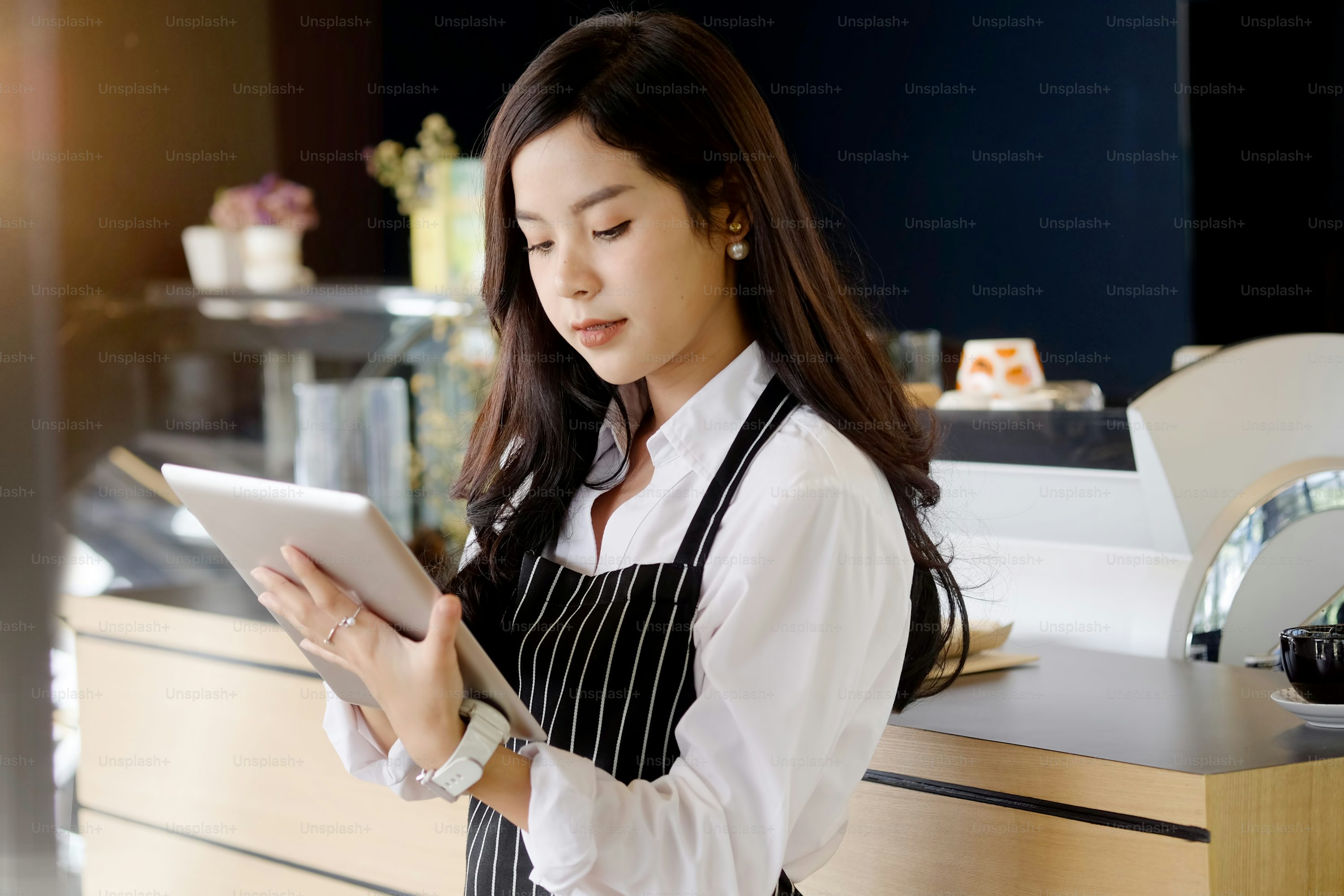 生成AI成功事例:コーヒーショップでタブレットを活用する女性